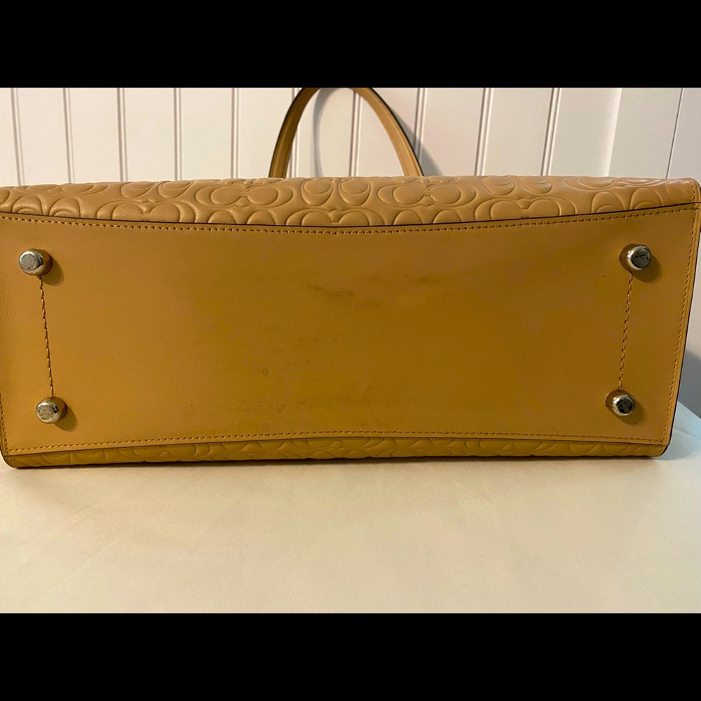 Very good condition tan  Coach handbag. Bottom has a smudge or two.